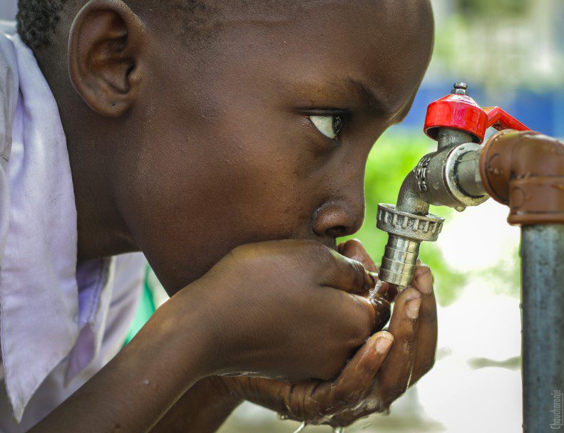 child drinking water from the tap